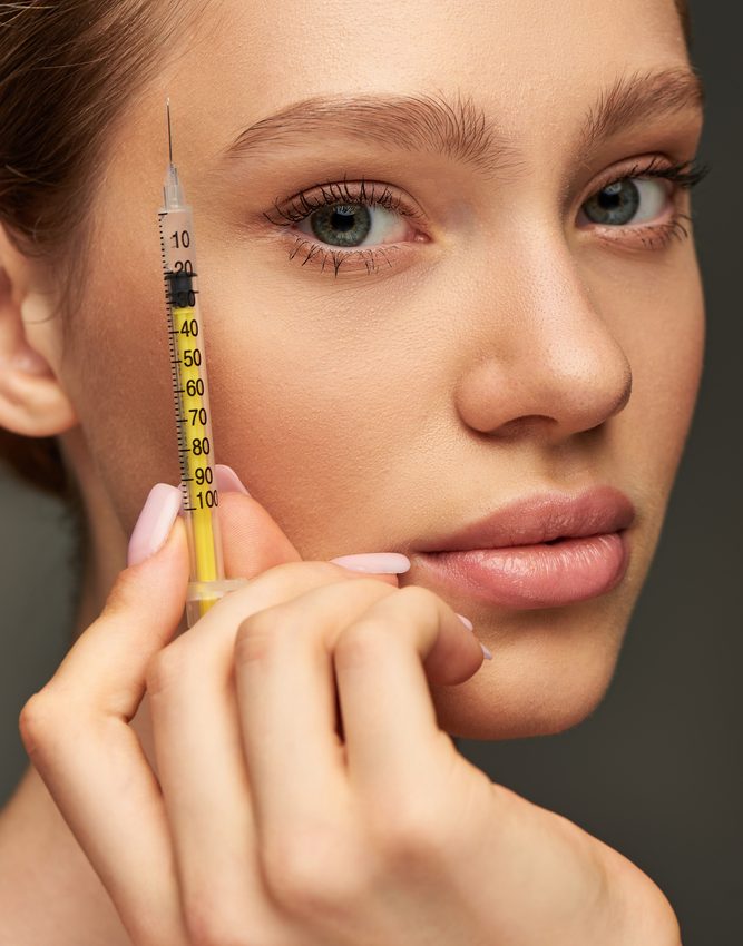 A lady holding a dermal filler needle