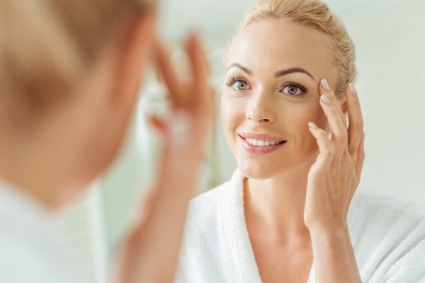 a woman putting skincare product on her face
